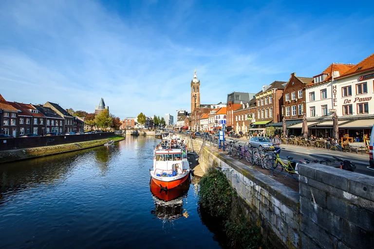 Roerkade waterfront in Roermond with a tour boat and street cafes