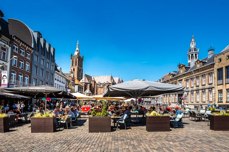 Market square in Roermond with pavement cafes, church tower and town hall