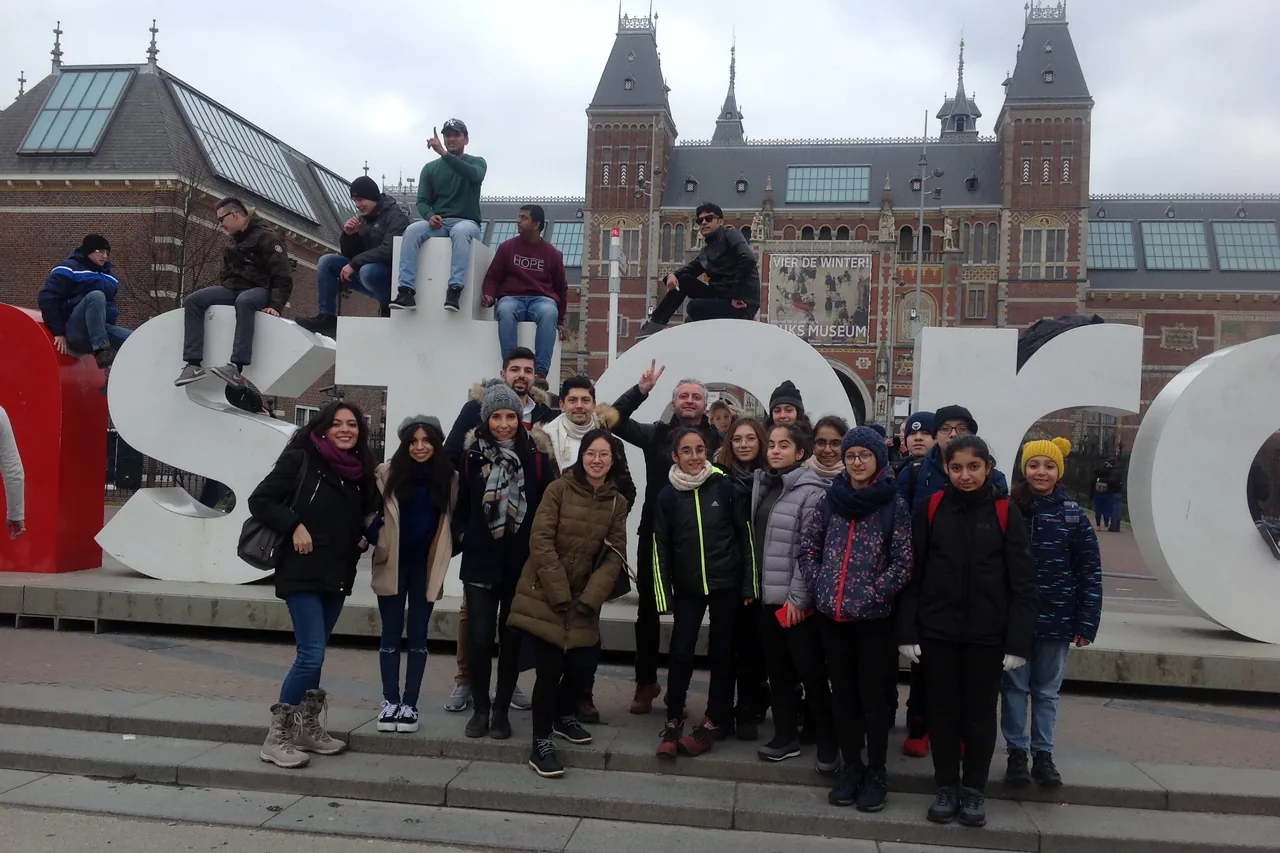 Group of young people in front of the lettering in Amsterdam